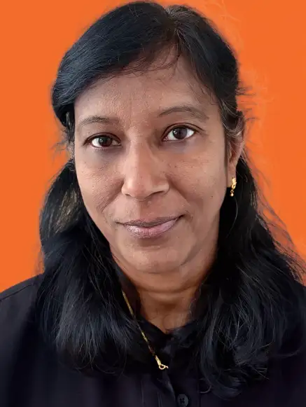 Middle-aged woman with short blonde hair wearing a blue shirt against an orange background.